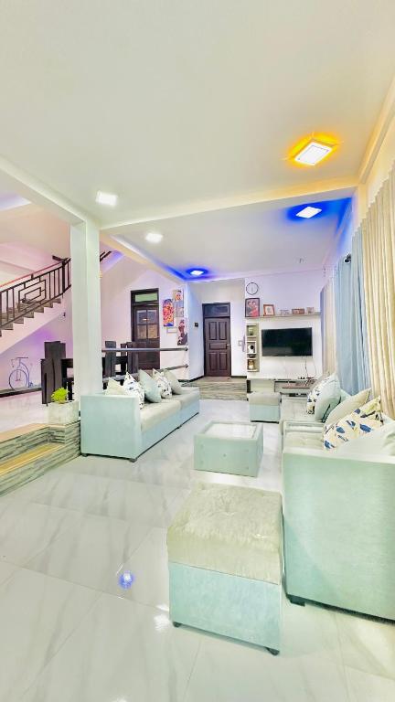 a large living room with couches and a tv at Hill Top Villa Kandy in Ambatenna