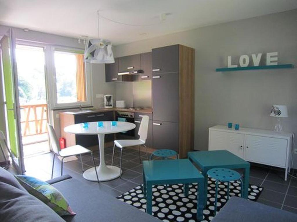 a living room with a table and a kitchen at Studio Le Vedeur in Durbuy