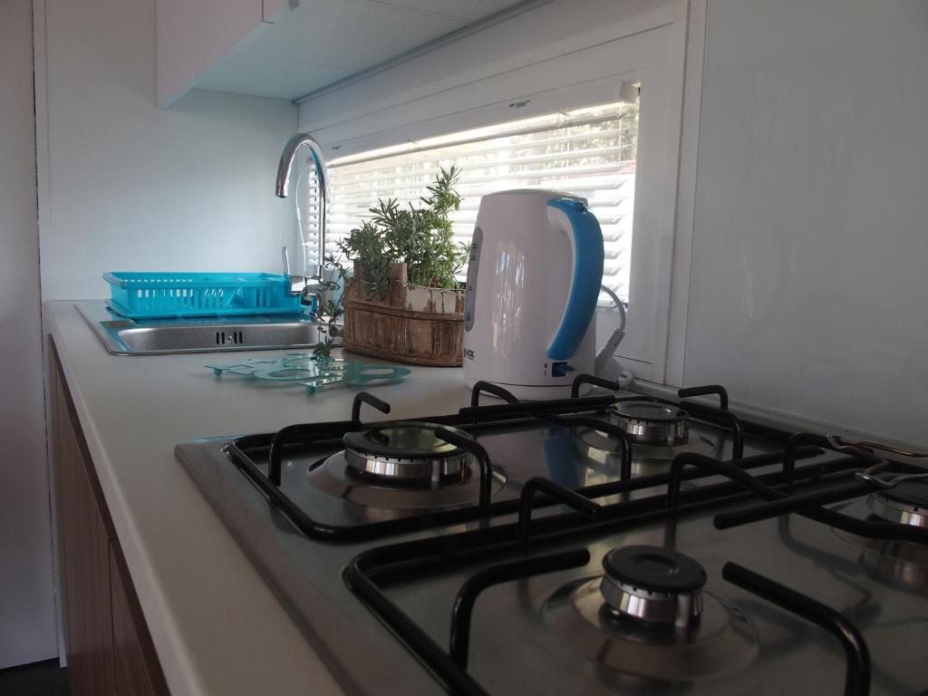ein Küchenkochfeld mit einer Spüle und einem Fenster in der Unterkunft Luxury MobileHome Lucina Bay in Pašman