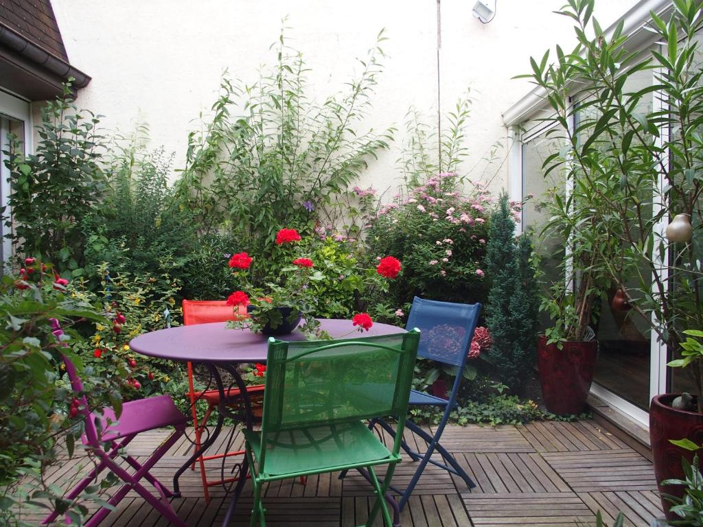einen Tisch und Stühle in einem Garten mit Blumen in der Unterkunft Bed and Breakfast Le patio in Montigny-lès-Metz