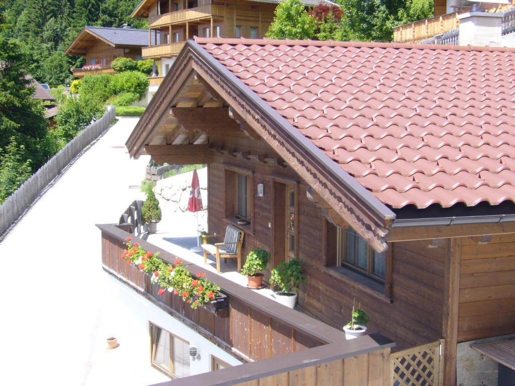ein Haus mit einem Balkon mit Pflanzen und Blumen in der Unterkunft Ferienwohnung Marlene in Alpbach