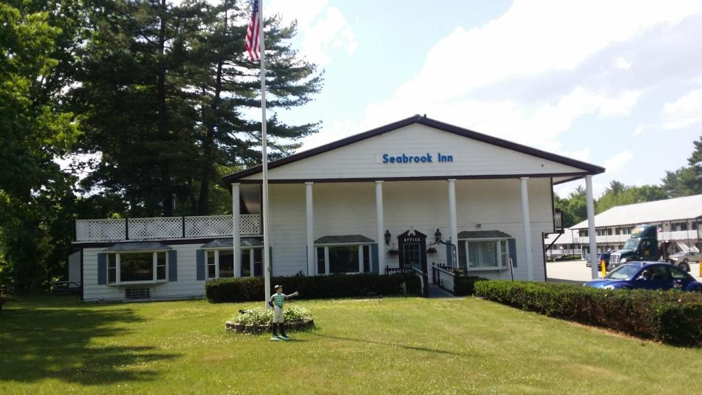 un homme debout dans une cour devant un bâtiment dans l'établissement Seabrook Inn, à Seabrook