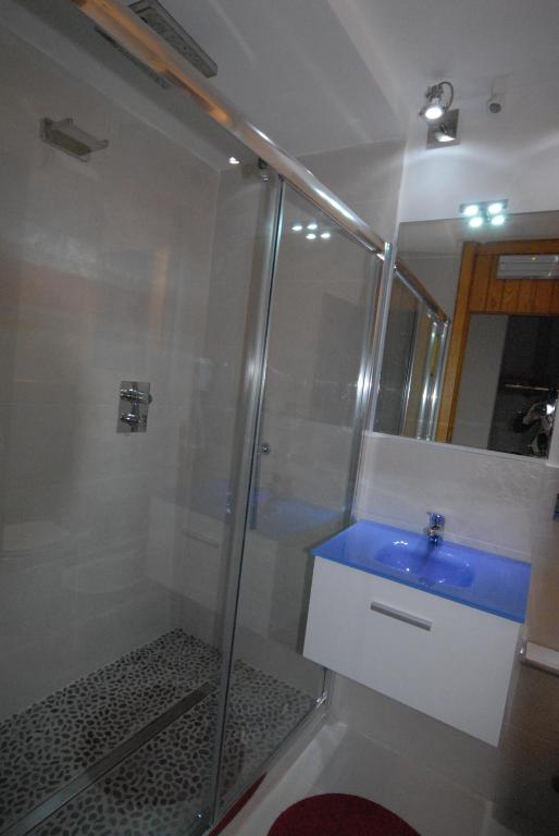 W łazience znajduje się prysznic i niebieska umywalka. w obiekcie Cromotherapy Apartment w mieście Breuil-Cervinia