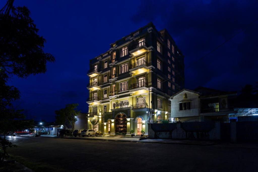 ein hohes Gebäude mit Lichtern in der Nacht in der Unterkunft Boutique Kampot Hotel in Kampot