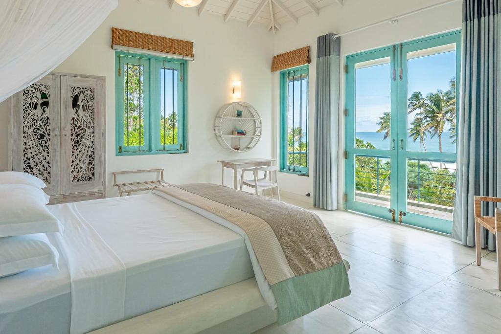 a bedroom with a bed and views of the ocean at Monara - Tangalle in Tangalle