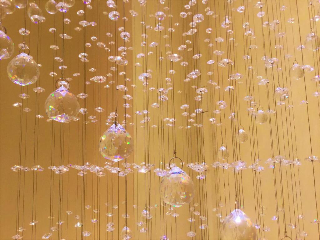 un mucchio di sfere di vetro appese a un muro di Hotel Marco Polo SELF CHECK-IN a Bologna