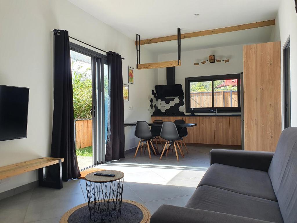 a living room with a couch and a table at L'écrin des calumets in La Plaine des Palmistes