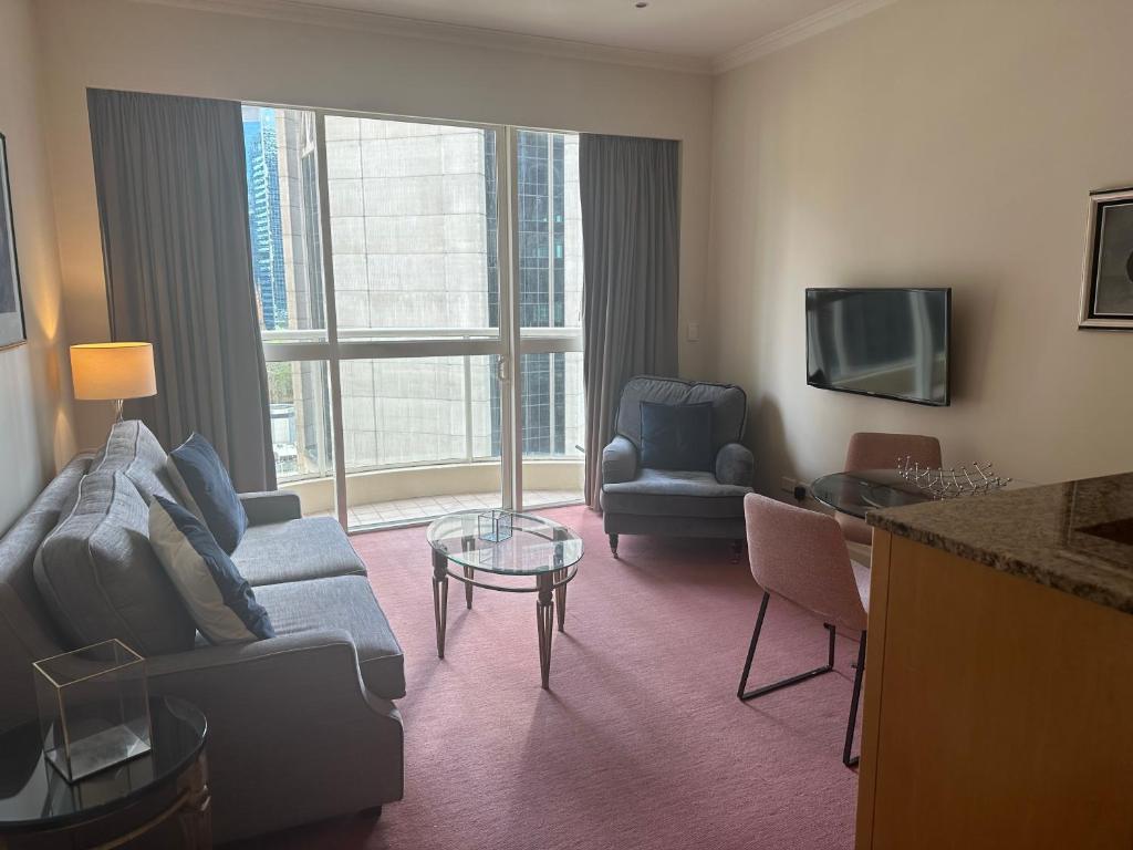 a living room with a couch and chairs in a hotel room at Central Apartment BON21409 in Sydney