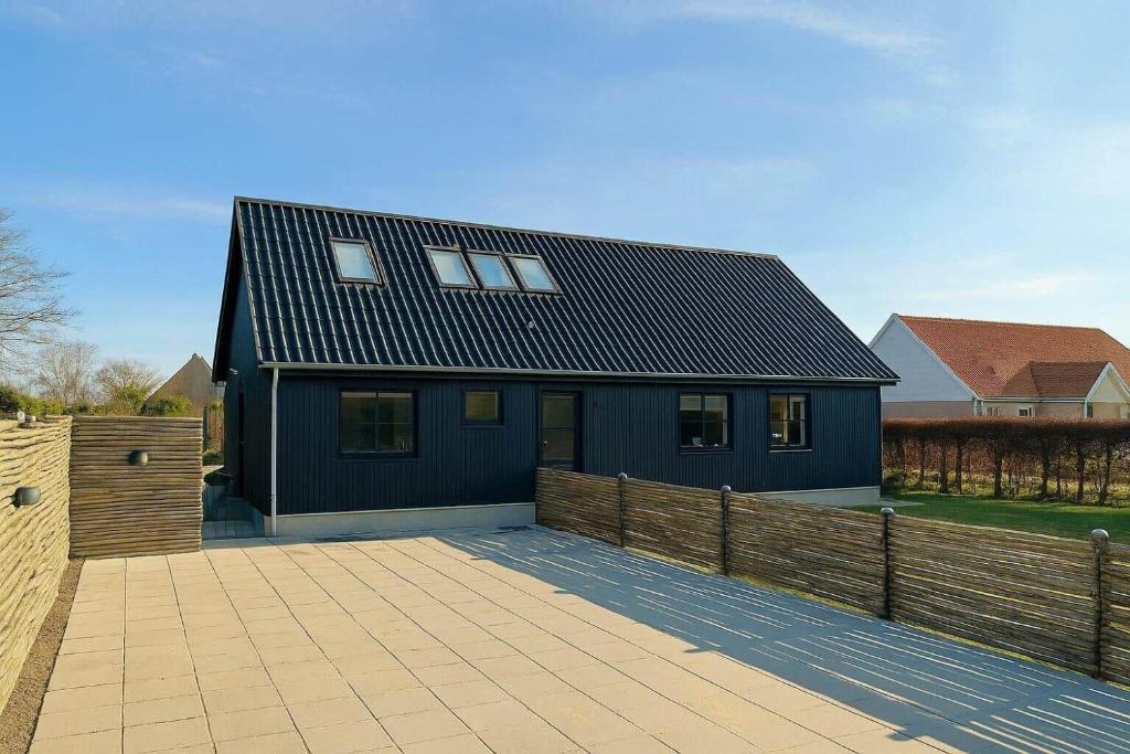 a blue house with a black roof and a fence at 20157-Samso-Ostre-Ringvej-14 in Nordby