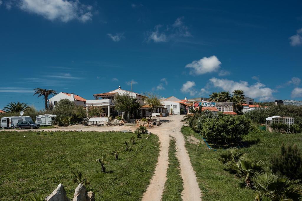 un camino de tierra en un campo con casas en Da Silva Surfcamp en Areia Branca