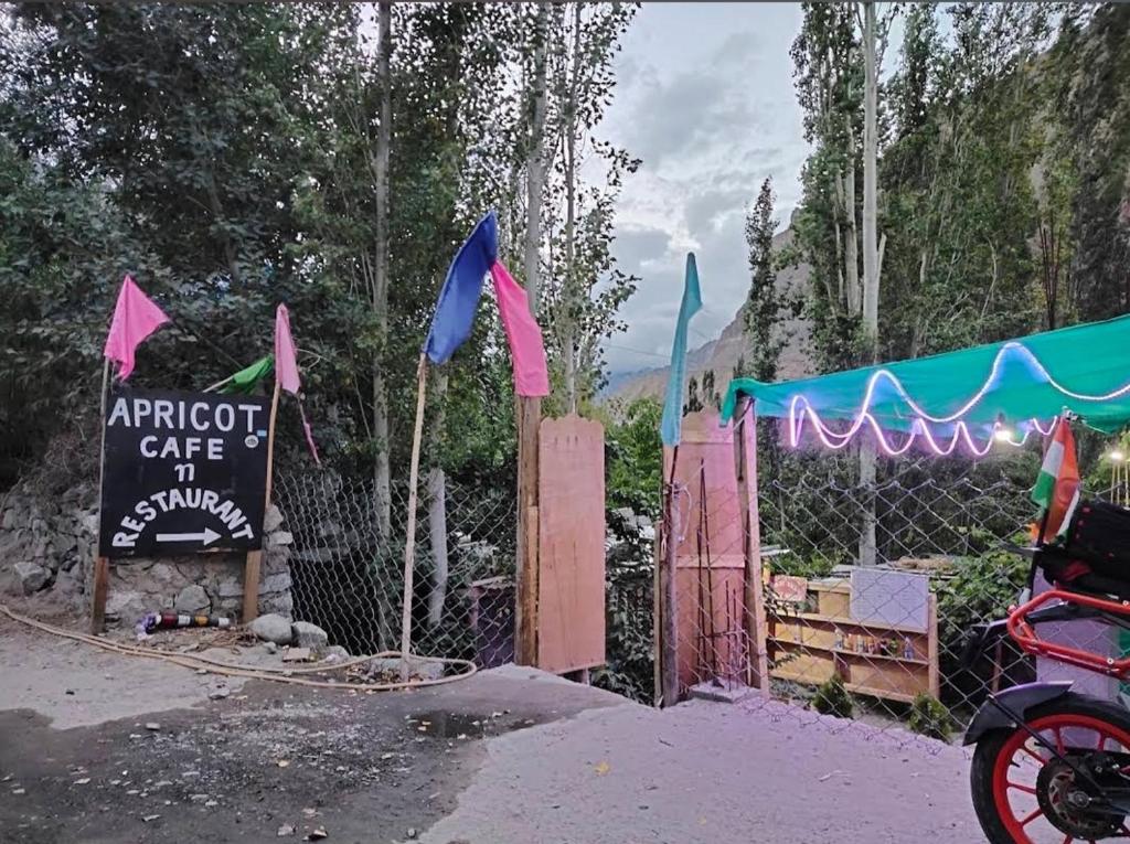 a gate with a sign and a stroller in front at Apricot Cafe and Restaurant Shapa in Turtuk