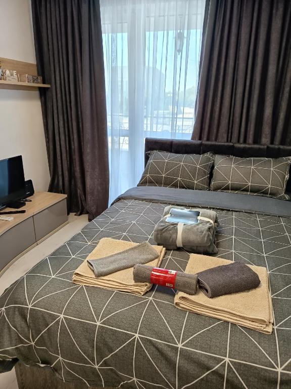 a bed with two pillows and towels on it at Hotel Rooms St Paul in Plovdiv