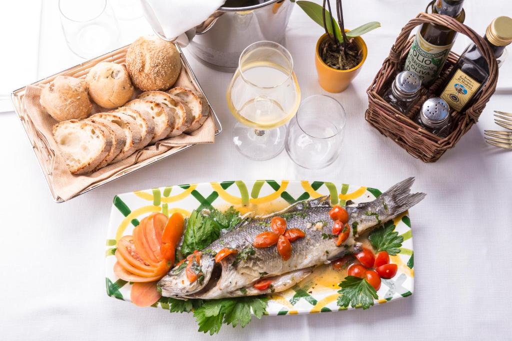 a table with a plate of fish and bread at Relais Regina Giovanna in Sorrento