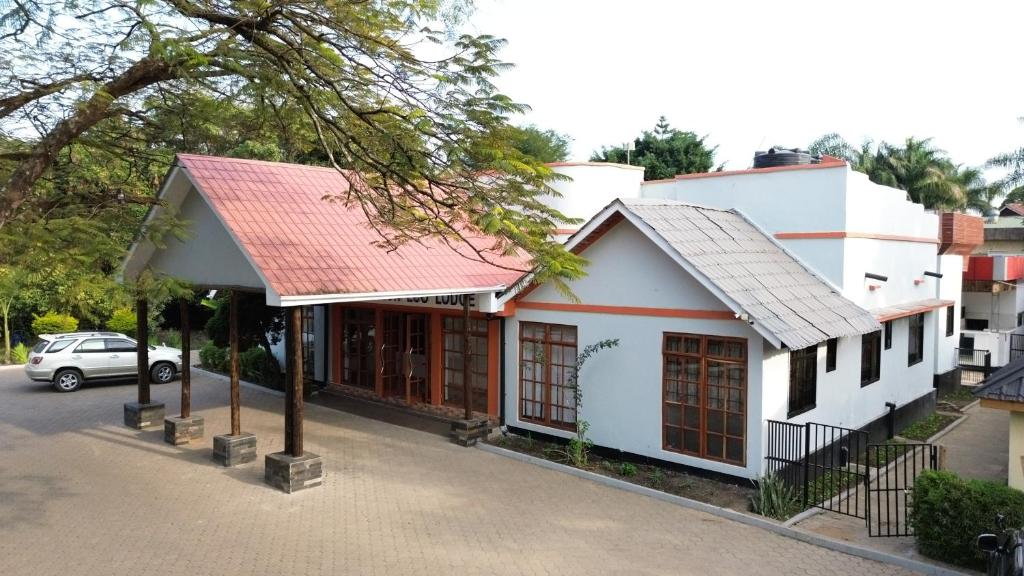 a small white building with a red roof at Blue Junction Eco Lodge in Arusha