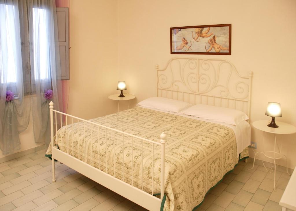 um quarto com uma cama branca e 2 candeeiros em Midiè B&B Savelletri em Savelletri di Fasano