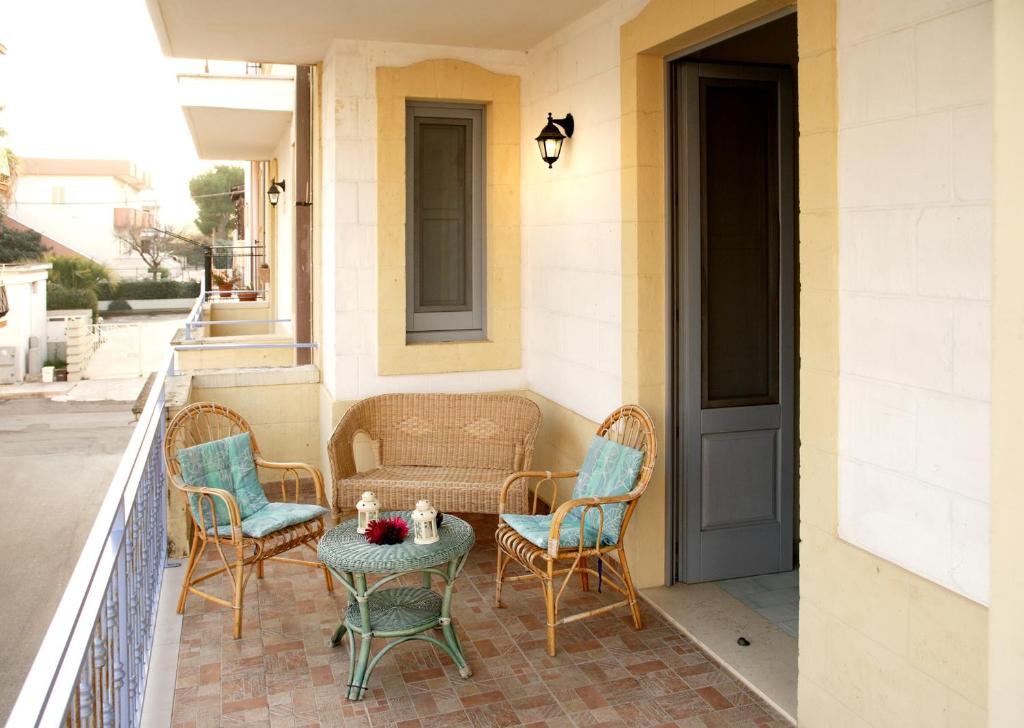 a porch with chairs and a table and a door at Midiè Savelletri in Savelletri di Fasano