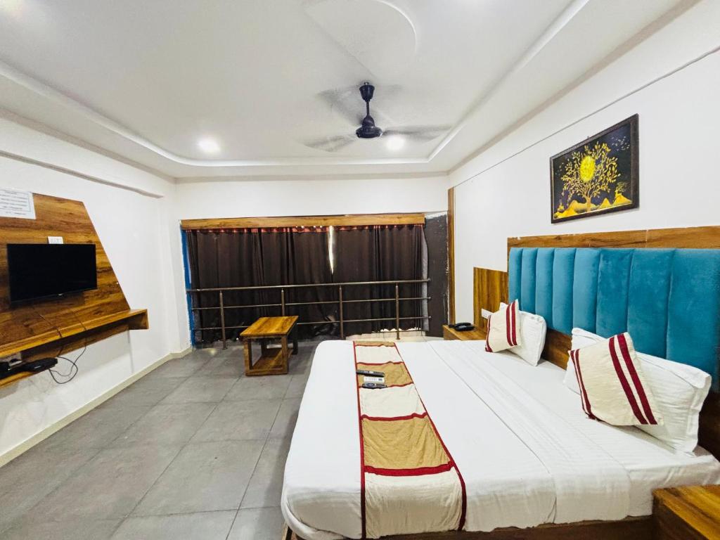 a room with a bed and a tv in it at Star Hotel in Ahmedabad
