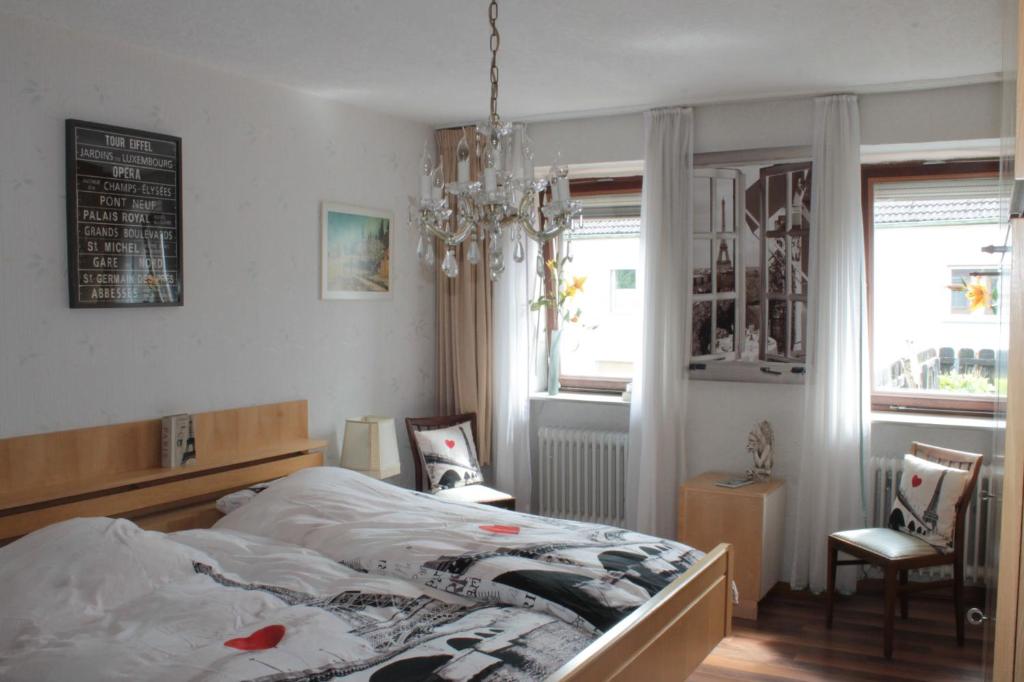 a bedroom with a bed and a chandelier at Pension Rodenburg in Duppach