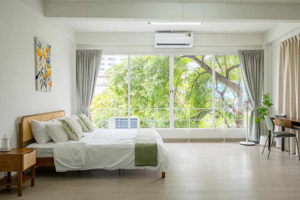 a bedroom with a bed and a large window at Glow House Sukhumvit 54, Spacious Modern Rooms near BTS On Nut in Bangkok