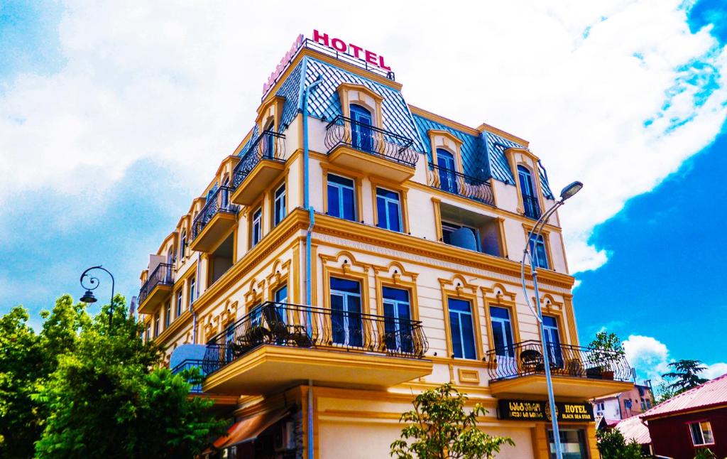 un edificio amarillo con un cartel encima en Black Sea Star Batumi en Batumi
