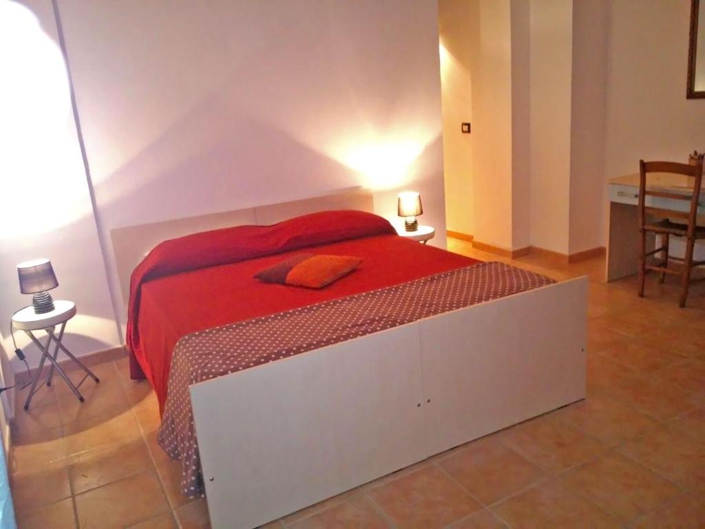 a bedroom with a large bed with a red blanket at B&B Porta Bazzano in LʼAquila