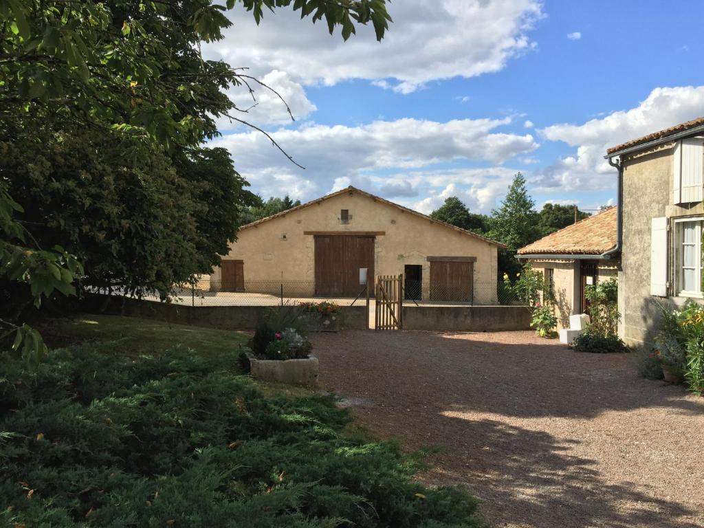 a house with a driveway leading to a garage at Chambres d'hôtes du puy d'anché in Sauzé-Vaussais