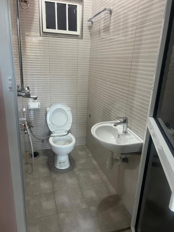 a bathroom with a toilet and a sink at Sunset Inn Lodge in Arusha