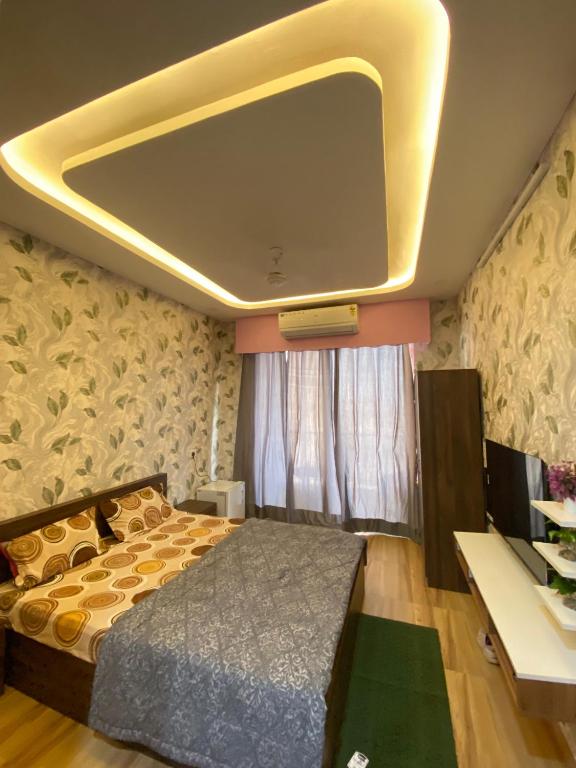 a bedroom with a bed and a tv on the ceiling at Kaveri City Center in Greater Noida