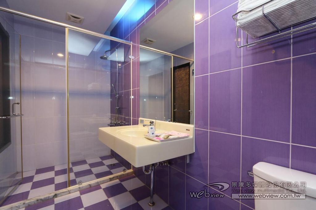 a purple bathroom with a sink and a mirror at Foot Track Bed and Breakfast in Hualien City