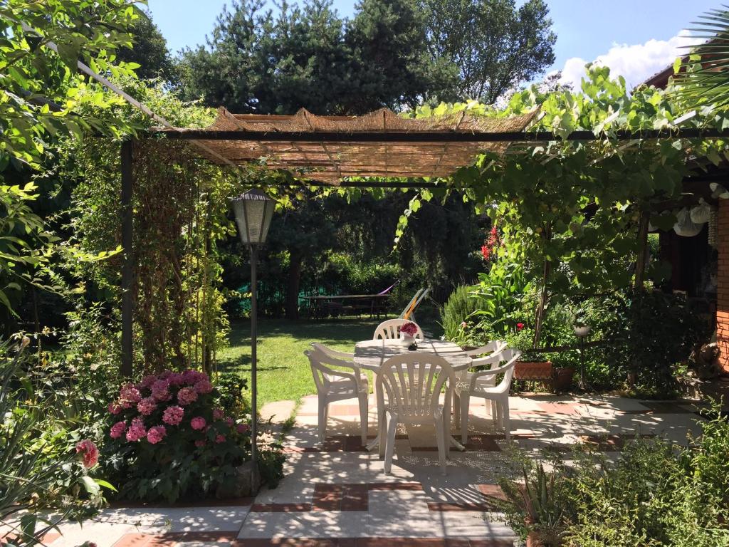 einen Tisch und Stühle unter einer Pergola im Garten in der Unterkunft Casa Curlo in Calvagese della Riviera