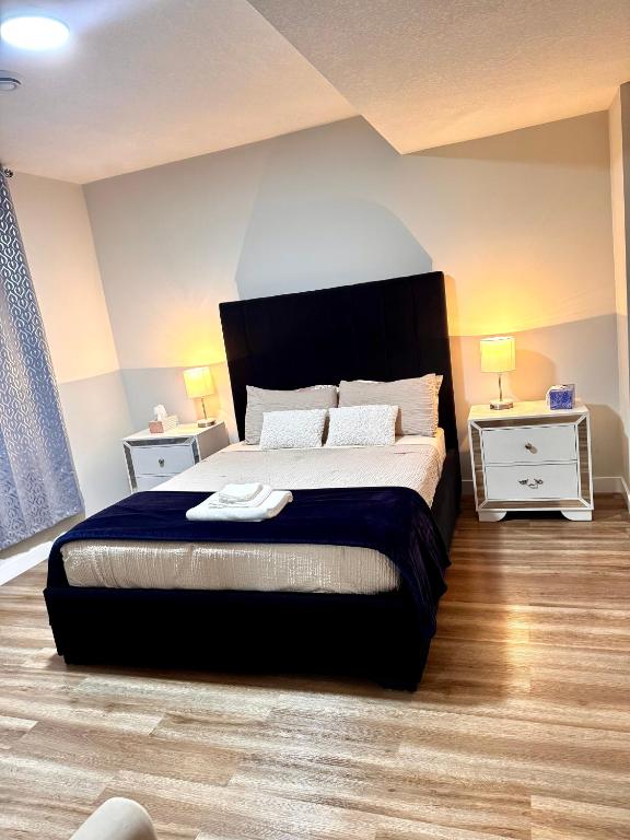 a bedroom with a large bed and two night stands at Homey Basement Suite by Gaudi in Calgary