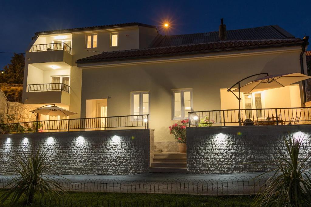 a white house with a fence and lights at Dida moj in Senj