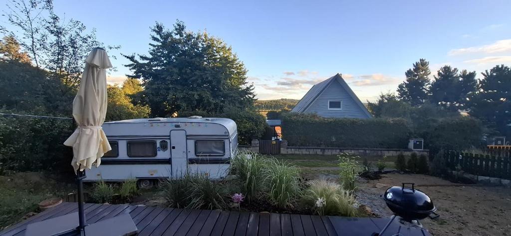 an rv parked in a yard with an umbrella at Chata Lipnice in Lipnice nad Sázavou