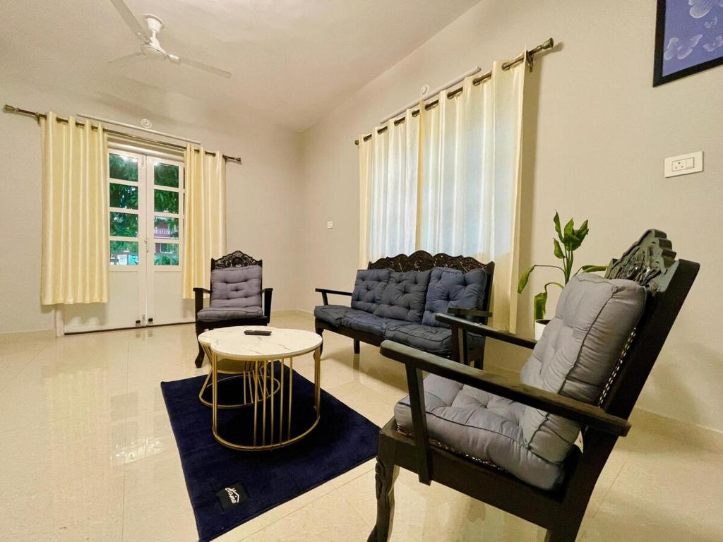 a living room with two chairs and a table at Wavehouse Retreat 1bhk with free Parking anirah in Colva