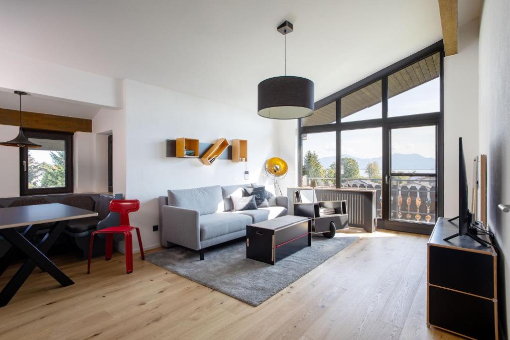 una sala de estar con un sofá y una mesa en Designer-Oberstüberl mit Seeblick auf den Chiemsee & Alpenpanorama, en Seebruck