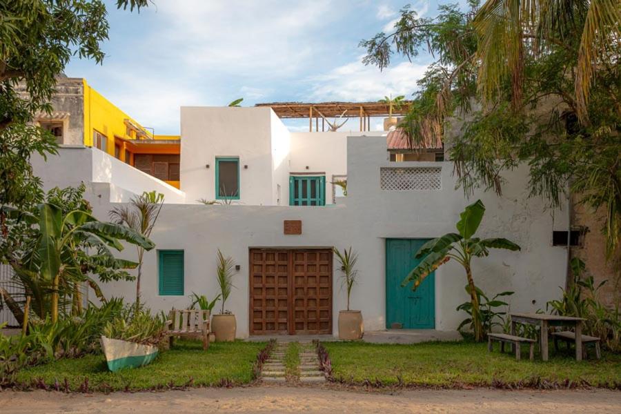 Casa blanca con puertas y árboles azules en Casa da Lua, en Isla de Mozambique