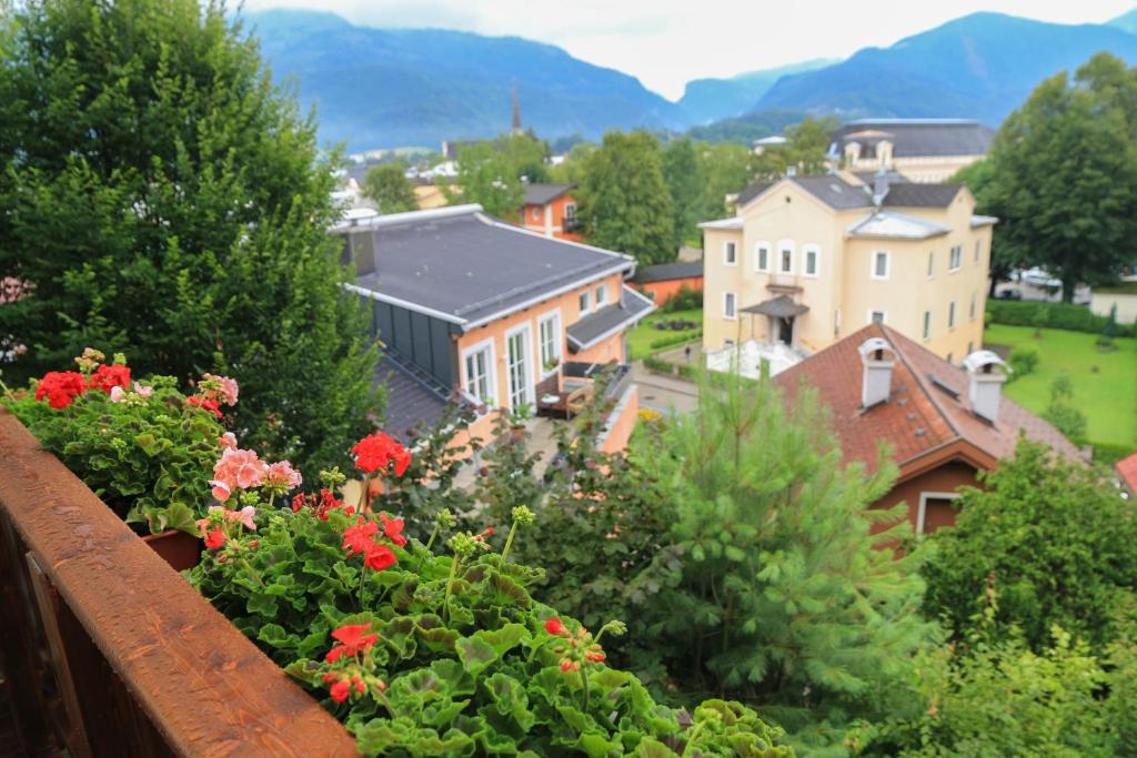 a view of a town from a balcony with flowers at Villa Leni - Premium Apartments in Bad Ischl