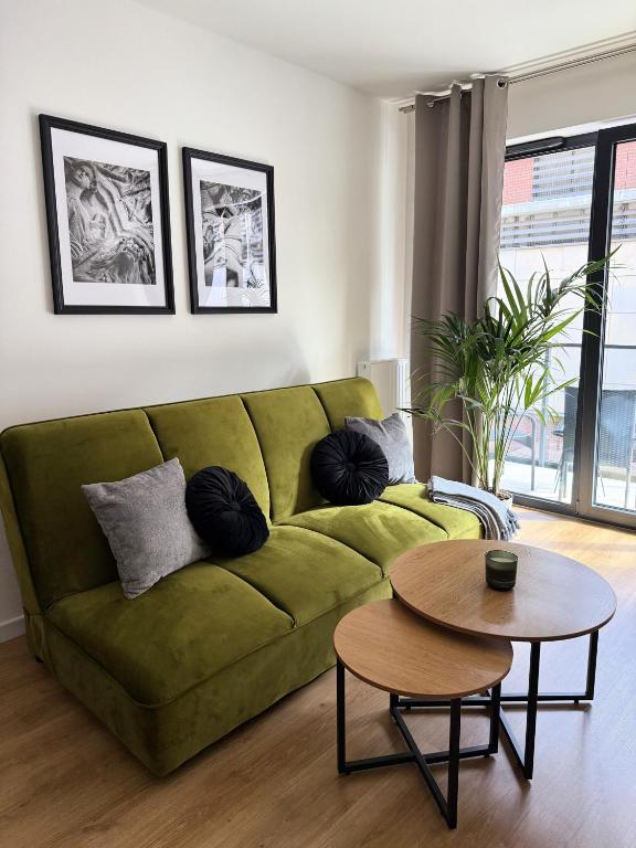 a living room with a green couch and a table at Justinrent PALATIUM 12 in Legnica