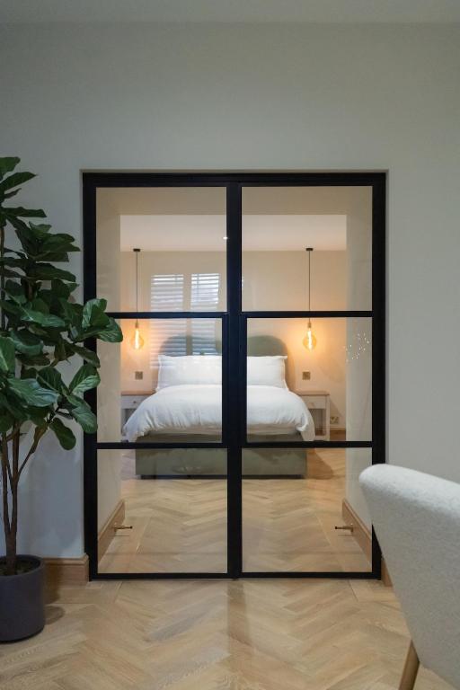 a bedroom with a bed inside of a glass wall at Luxury Flat in Shaftesbury by JOT STAYS in Shaftesbury