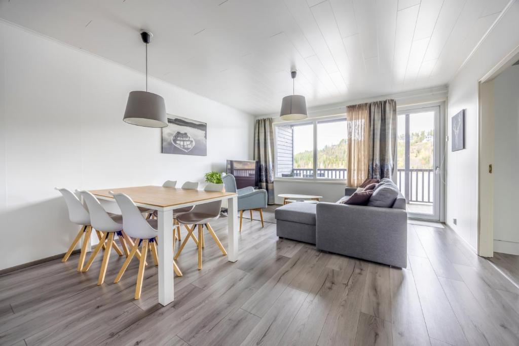 a dining room and living room with a table and chairs at Järvenrantahuoneisto LakeVillas B1 in Ukkohalla