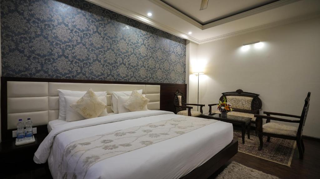 a bedroom with a large white bed and a chair at KIIT Residency Patia, Bhubaneswar in Bhubaneshwar