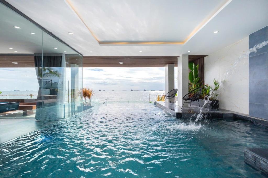 a swimming pool in a house with a view of the ocean at Villas VIP Trực Diện View Biển GREEN DAY 24 Sang Trọng in Vung Tau