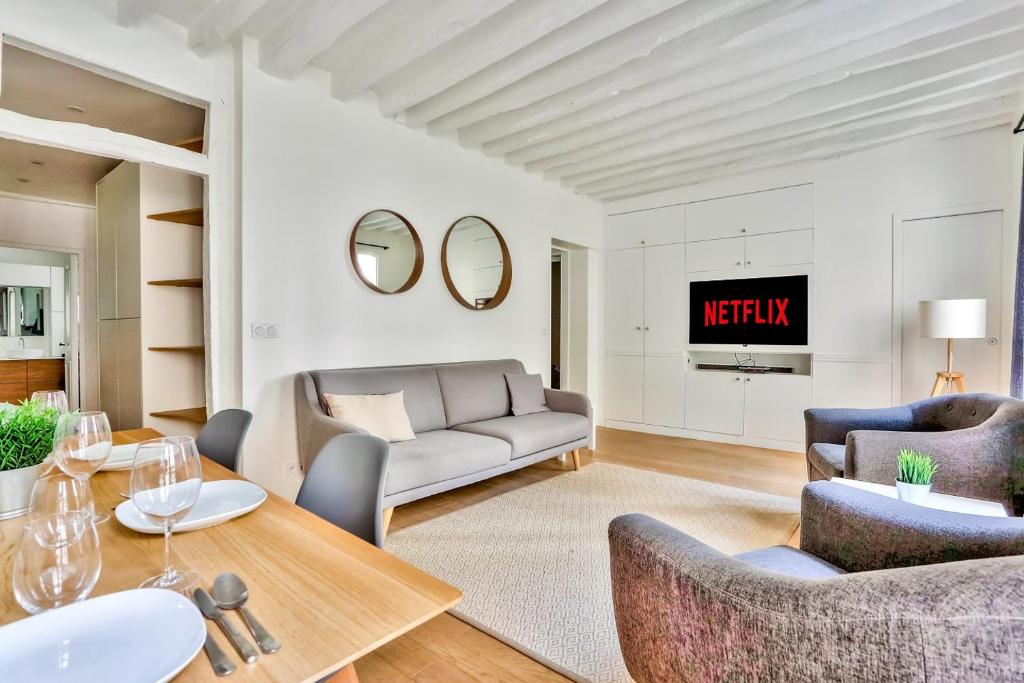 a living room with a couch and a table at Superbe Appartement Bon marché Saint Germain Free Netflix in Paris