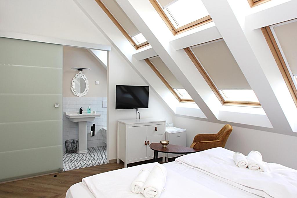 リュブリャナにあるD Roomsの天窓のある屋根裏部屋の寝室とベッドが2つある部屋