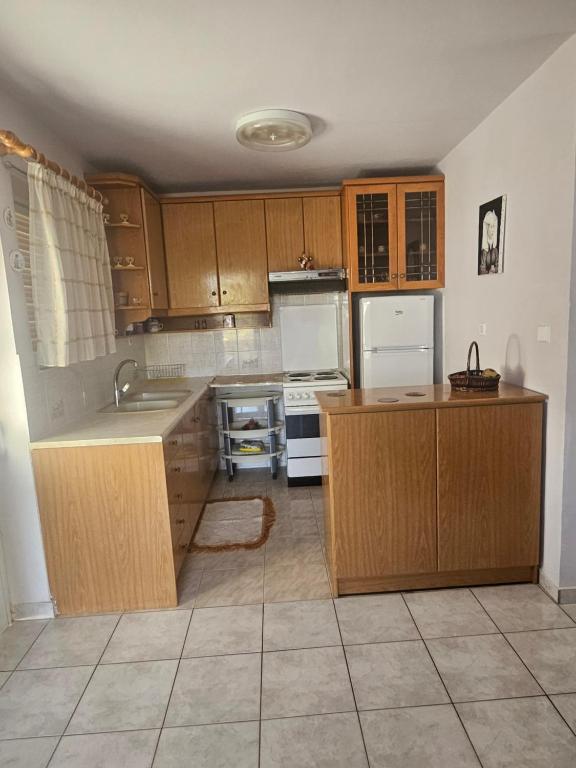 a kitchen with wooden cabinets and white appliances at Country Home in Áyios Spirídhon