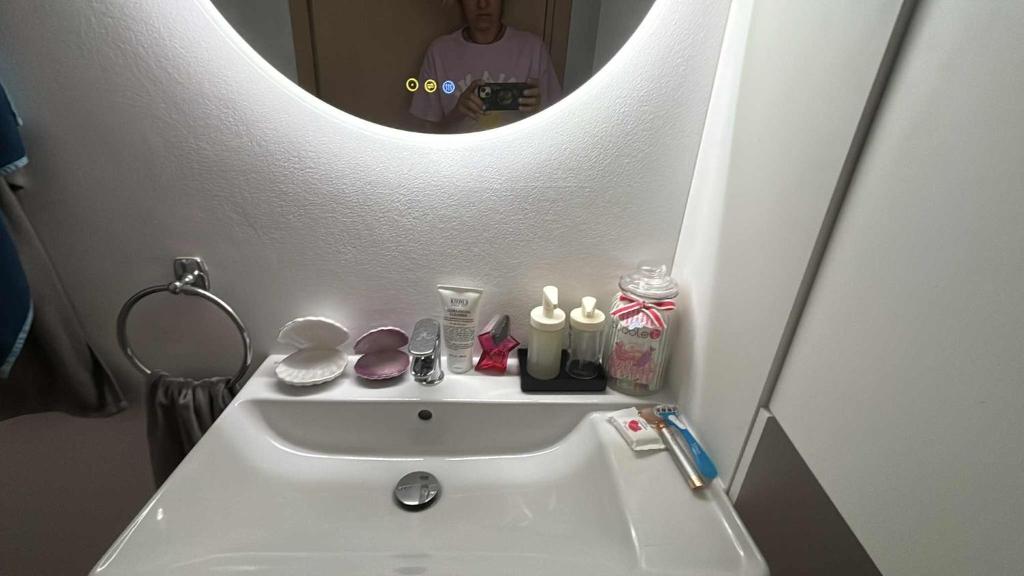 a bathroom with a sink with a mirror above it at Amphithea Luxury Apartment in Voroklini