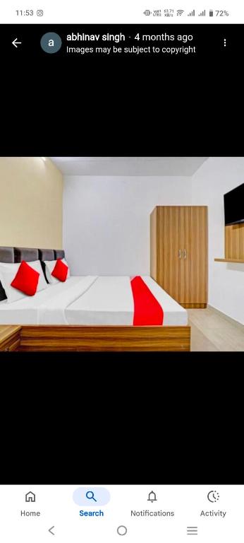 Una foto de un dormitorio con una cama con almohadas rojas en Hotel Pacific view, en Dehradun