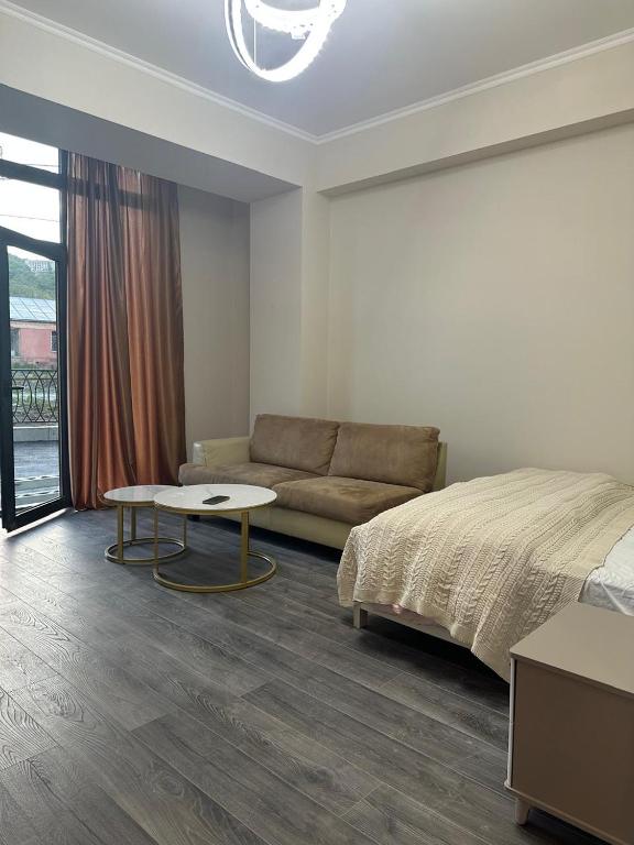 a bedroom with a bed and a couch and a table at Alvina Terrace in Tsaghkadzor