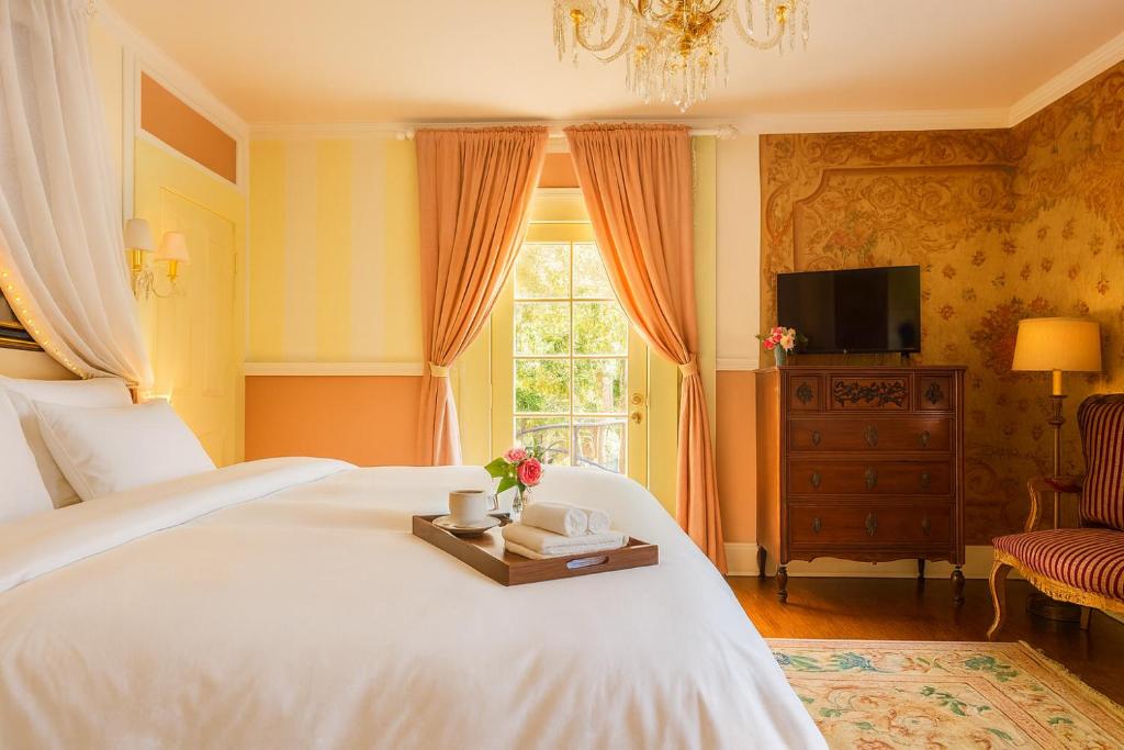 a bedroom with a white bed with a tray with flowers on it at Iconic Hollywood Homestay Near Walk Of Fame in Los Angeles