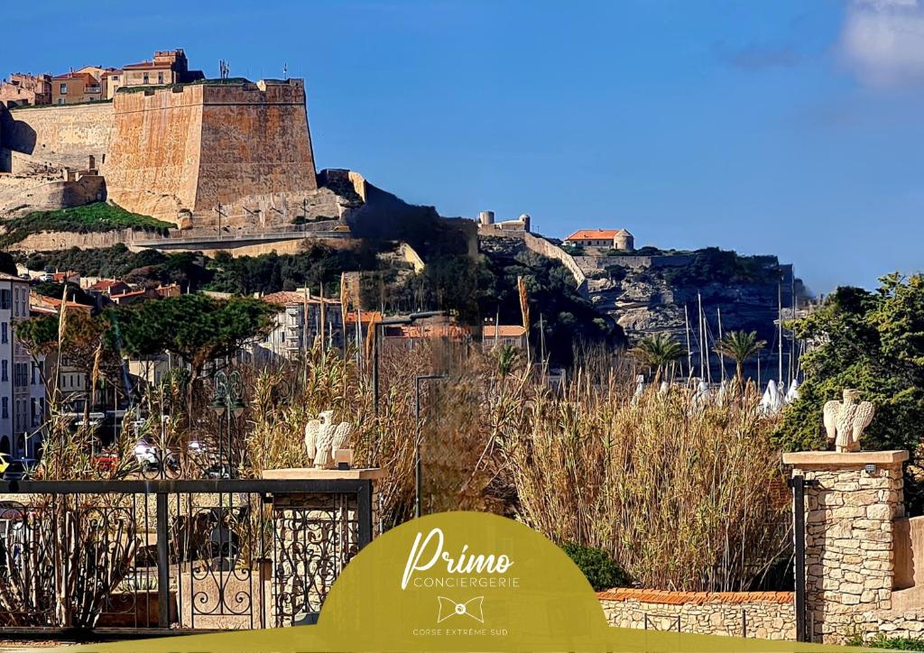 un panneau devant une colline avec un château dans l'établissement Appartement Kallisté, Logements avec vue citadelle de Bonifacio, à Bonifacio